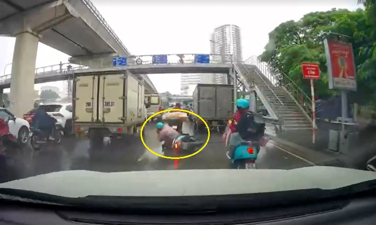 Mải dùng điện thoại người đàn ông đi xe máy ngã lăn ra đường