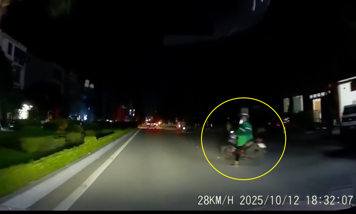 Người phụ nữ dừng xe máy giữa đường nghe điện thoại