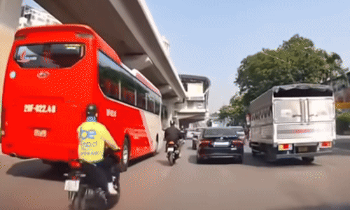 Người đi xe máy thoát chết dưới bánh xe khách